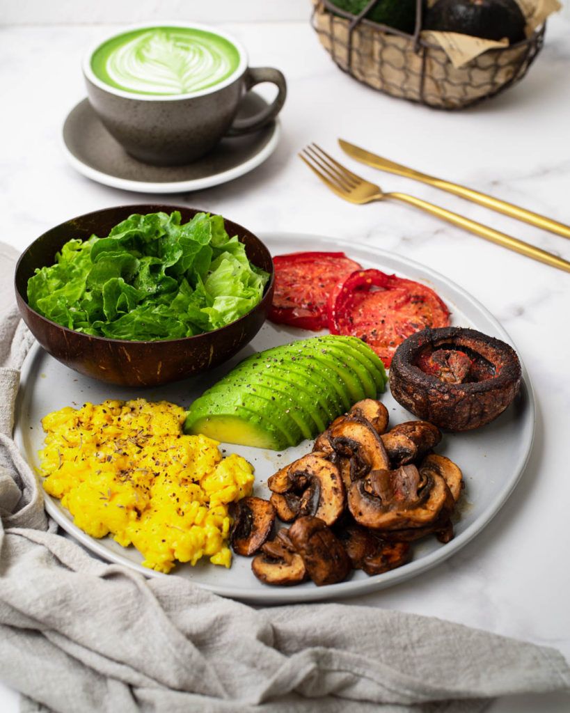 Vegetarian keto full English breakfast with portobello, eggs, avocado, and mushrooms